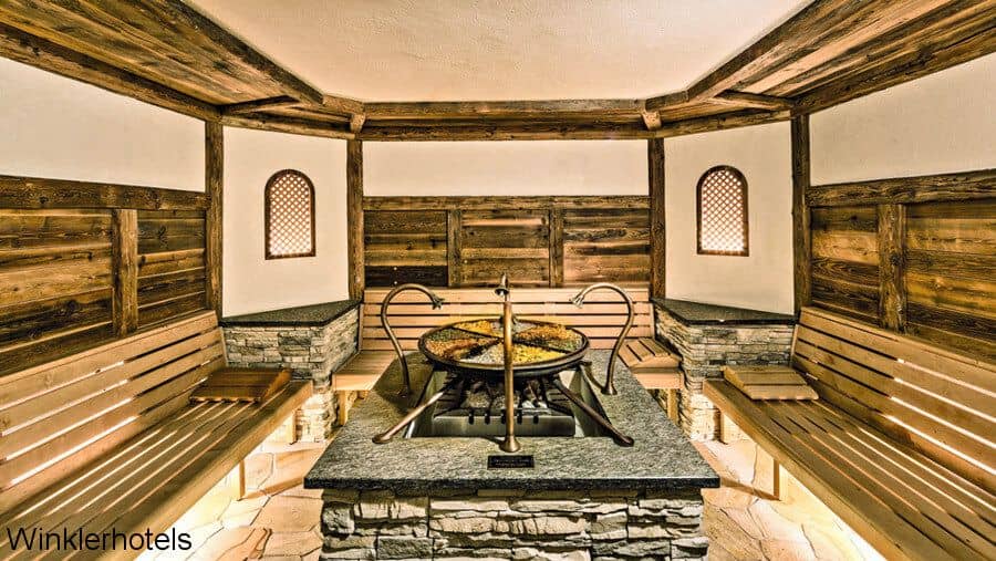 Для оформления просторной сауны отеля Lanerhof (Италия) выбрана скрытая фоновая подсветка, деликатно подчеркивающая фактуру натурального дерева, природного камня и полированного металла